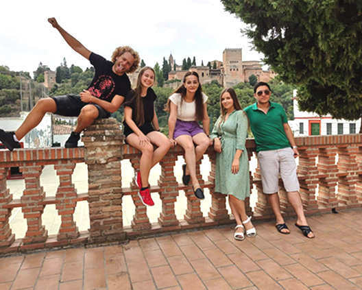 erasmus students smiling and in the background is Alhambra Castle and Genil
